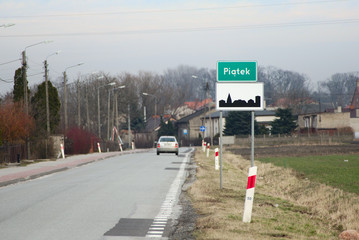 The sign at the entrance to the village of Piatek, where the geometric center of Poland is located. - obrazy, fototapety, plakaty