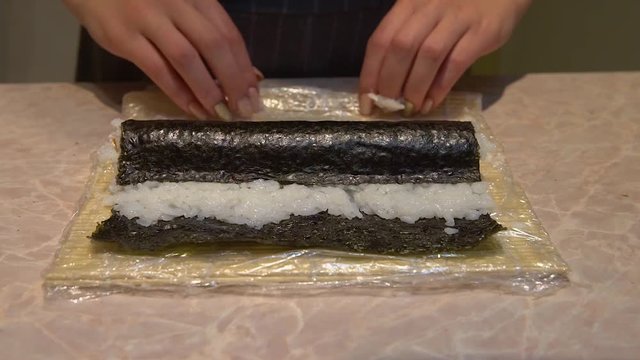 Close up of a woman preparing homemade sushi