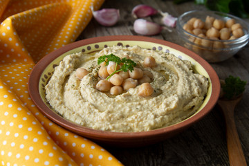 Delicious homemade hummus pasta with olive oil and chick-peas. Wooden table. Healthy food.