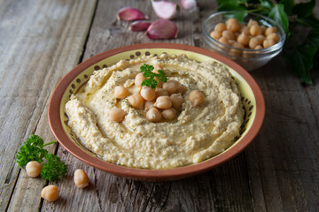 Delicious homemade hummus pasta with olive oil and chick-peas. Wooden table. Healthy food.