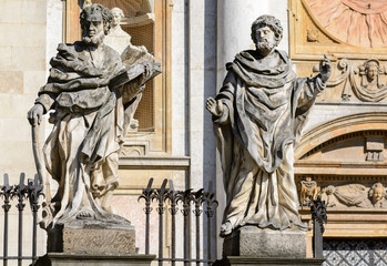 Naklejka premium Krakow. In the lower part of the facade of the Cathedral of Saints Peter and Paul there are 4 statues of the most famous Jesuits, above the entrance there is an emblem of the Jesuit Order.