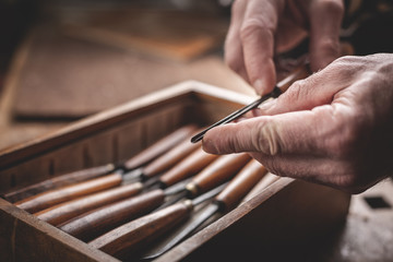 Erfahrene Hände halten ein Holzwerkzeug