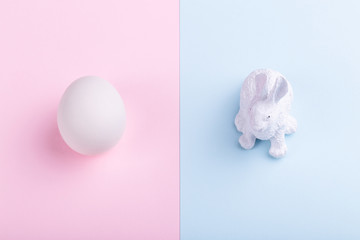 Easter rabbit and white egg on a pink-blue background, concept Happy Easter