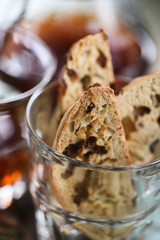 Close up of homemade traditional Italian biscotti or cantucci with raisins in glass served with coffee