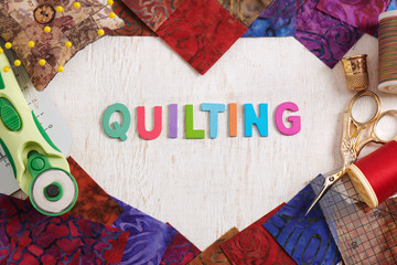 Wooden letters, consisting to the word quilting surrounded by accessories for quilting