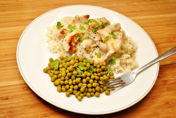Pork with Cream Sauce Over White Rice & a Side Dish of Peas