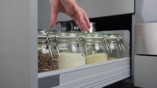 Women picking an item from storage hutch. Smart kitchen organization concept