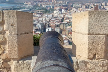 A rusty old canon points out towards the Mediterranean taking aim at the modern marina and the city below