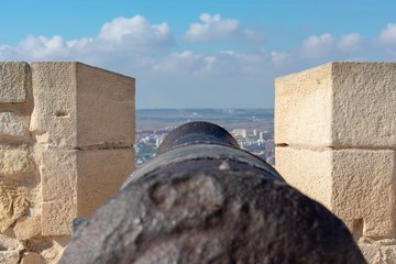 A rusty old canon points out towards the Mediterranean taking aim at the city of Alicante, Spain below