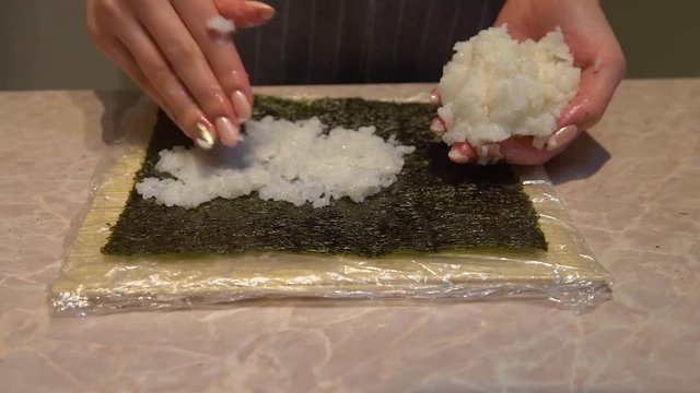 Close up of a woman preparing homemade sushi