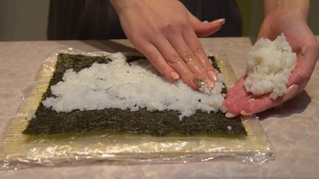 Close up of a woman preparing homemade sushi