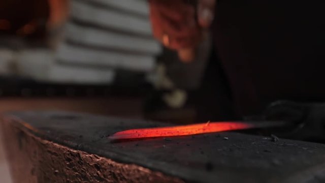 Making a knife from hot steel. Slow motion