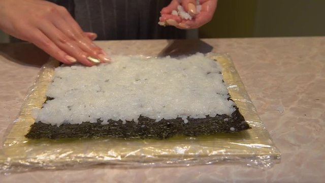 Close up of a woman preparing homemade sushi