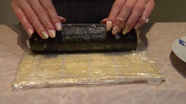 Close up of a woman preparing homemade sushi