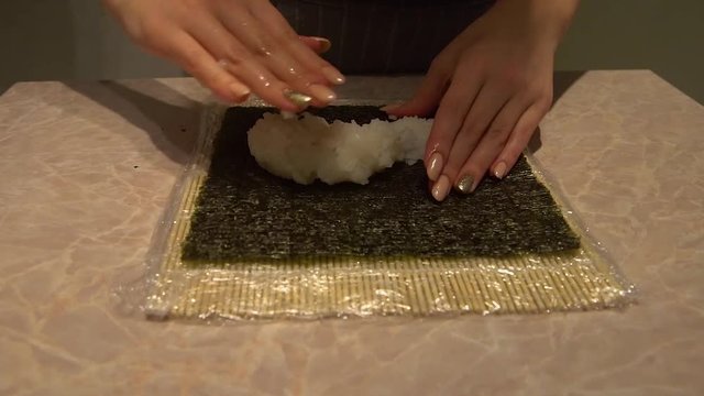 Close up of a woman preparing homemade sushi