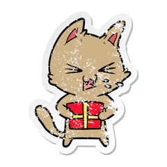 distressed sticker of a cartoon hissing cat with christmas present