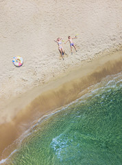 Adorable kids have fun on the beach. Aerial drone bird's eye view photo.