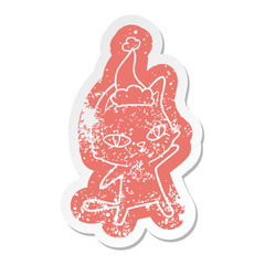cartoon distressed sticker of a cat staring wearing santa hat