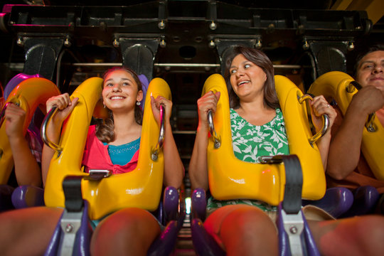Happy mother and daughter on a ride at an amusement park.
