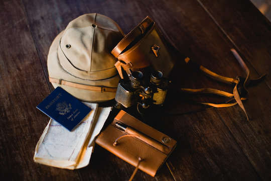 Passport a long with binoculars and a safari hat and notebook.