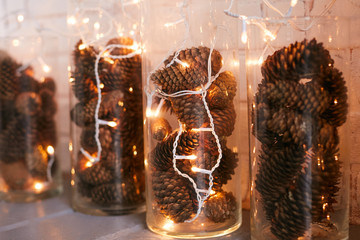 Glass flasks with fir cones decorated with white garland