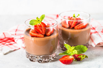 Chocolate panna cotta sweet dessert with strawberries in glass.
