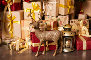 Christmas gifts wrapped in paper and decorated with a gold ribbon with a bow. The figure of a deer.