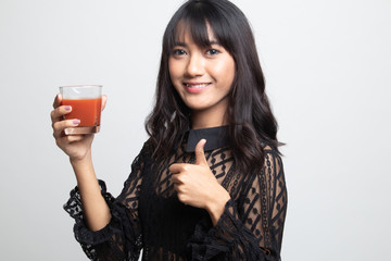 Young Asian woman thumbs up with tomato juice.