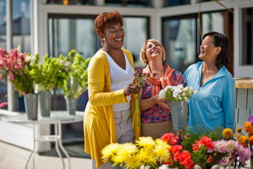 Happy friends enjoying a day out at a flower market.
