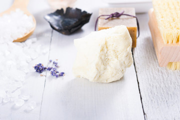 spa massage mud and clay powder, soaps, bath salt, shea butter and lavenders on white wood table background