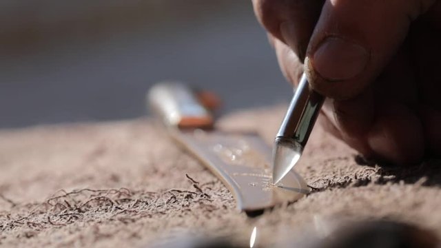 engraving on the blade of a metal knife. slow motion