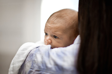 Baby held in its mother&#x27;s arms.