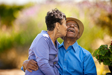 Senior woman kissing her happy husband.