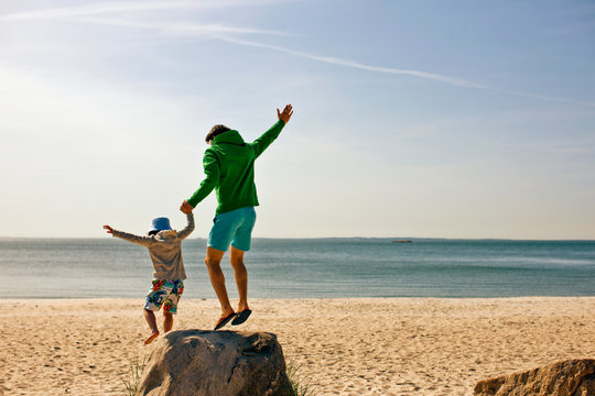Father and young son have fun at beach.
