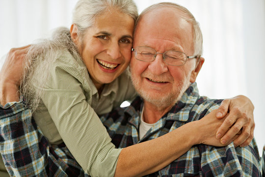 Portrait of a senior woman with her arms around her husband.