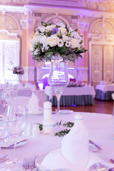 Banquet decorated table, with cutlery. Wedding decor in the banquet hall. Serving of a festive table, plate, napkin, knife, fork. Table setting decoration. Romantic Dinner or other events - wedding.