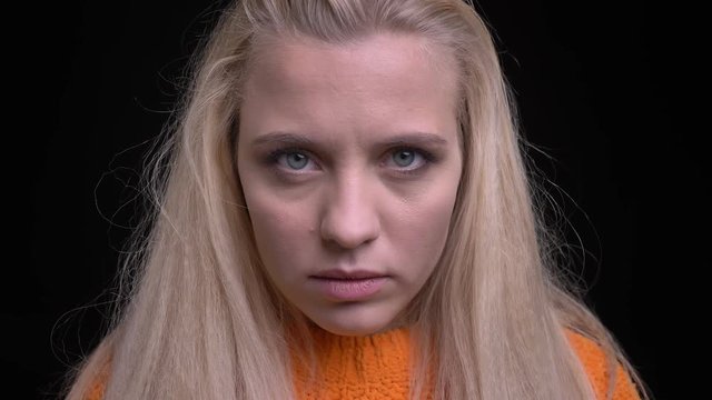 Closeup portrait of young stylish caucasian girl with long blonde hair looking straight at camera