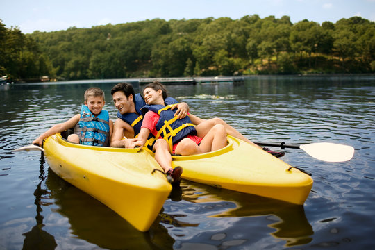 Happy family kayaking on a lake.