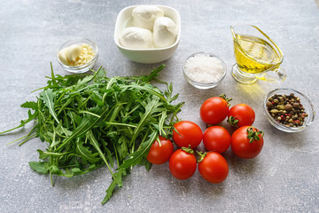Italian cuisine. Vegetarian food. Ingredients for salad with mozzarella, arugula and cherry tomatoes.