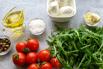 Italian cuisine. Vegetarian food. Ingredients for salad with mozzarella, arugula and cherry tomatoes.