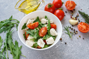 Italian cuisine. Vegetarian food. Salad with mozzarella, arugula and cherry tomatoes.