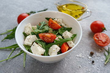 Italian cuisine. Vegetarian food. Salad with mozzarella, arugula and cherry tomatoes.