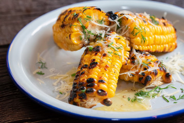 Close up grilled corn on the cob in white plate