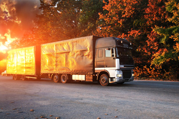 Fototapeta na wymiar Truck on the highway at autmun on the sunset