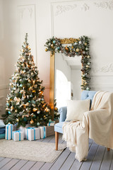 Beautiful Christmas tree with toys in a modern interior. Christmas gifts under the tree