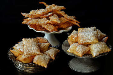 Faworki and Chiacchiere on a black background. A typical Italian dessert for the carnival. Traditional Polish dessert