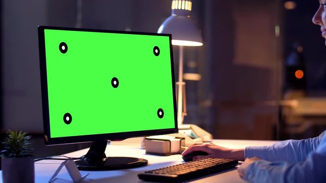 technology, virtual effects and business concept - businesswoman with chroma key green screen on computer monitor at night office