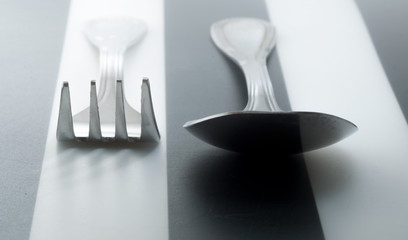 Fork and spoon on a striped geometric background