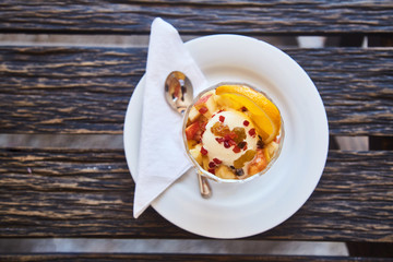 Fresh fruit salad in a plate on a wooden background