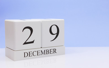 December 29st. Day 29 of month, daily calendar on white table with reflection, with light blue background. Winter time, empty space for text